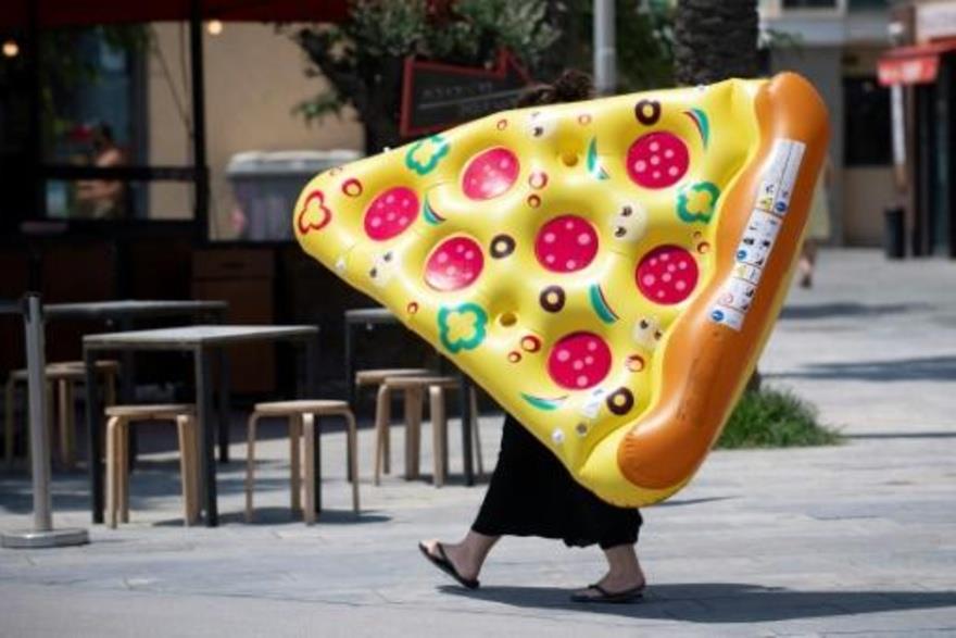 امرأة تحمل عوامة على شكل شريحة بيتزا في برشلونة