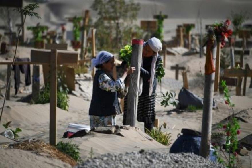 امرأتان من الأويغور في مقبرة في منطقة شينجيانغ الش