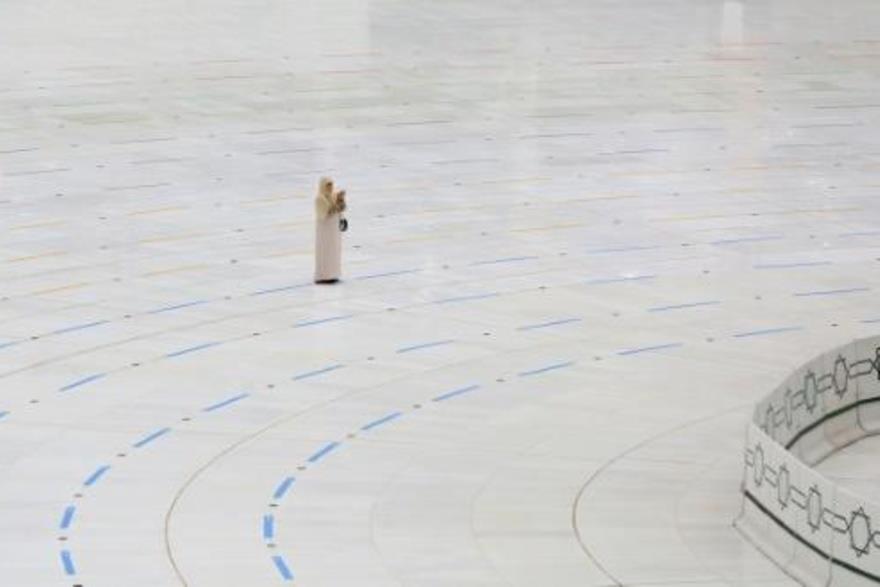 امرأة تقف قرب الكعبة في مكة المكرمة