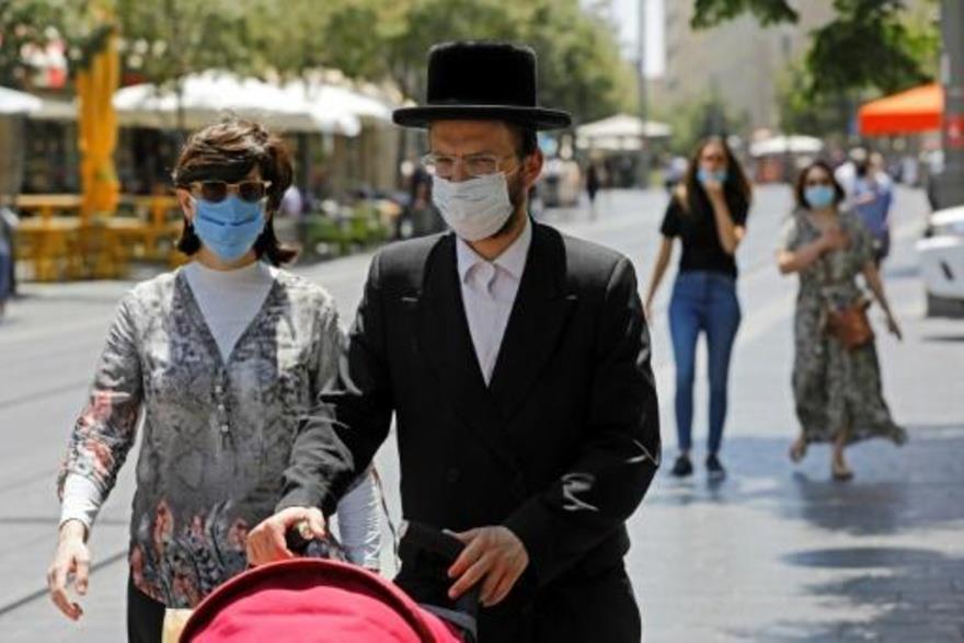 إسرائيليون يضعون الكمامات الواقية من فيروس كورونا 