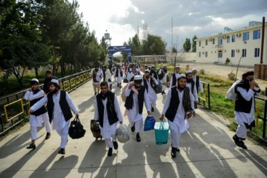 سجناء من حركة طالبان يسيرون حاملين أغراضهم خلال عم