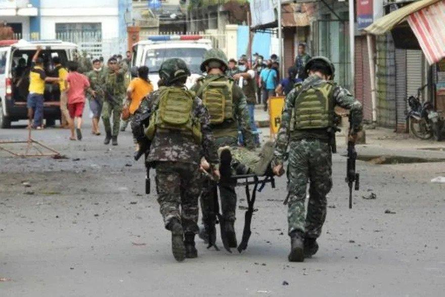 جنود ينقلون جريحا بعد التفجيرين الانتحاريين في جول