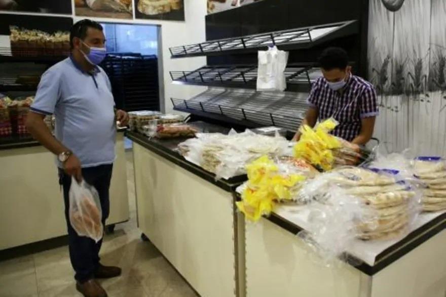 رجل يضع كمامة ويشتري خبزاً في العاصمة الليبية طراب