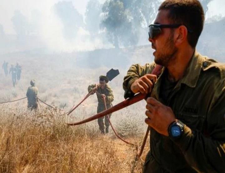   عسكريون إسرائيليون بحاولون إطفاء حريق اندلع في ح