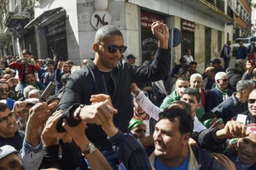  صورة من الأرشيف تظهر متظاهرين جزائريين يحملون الص