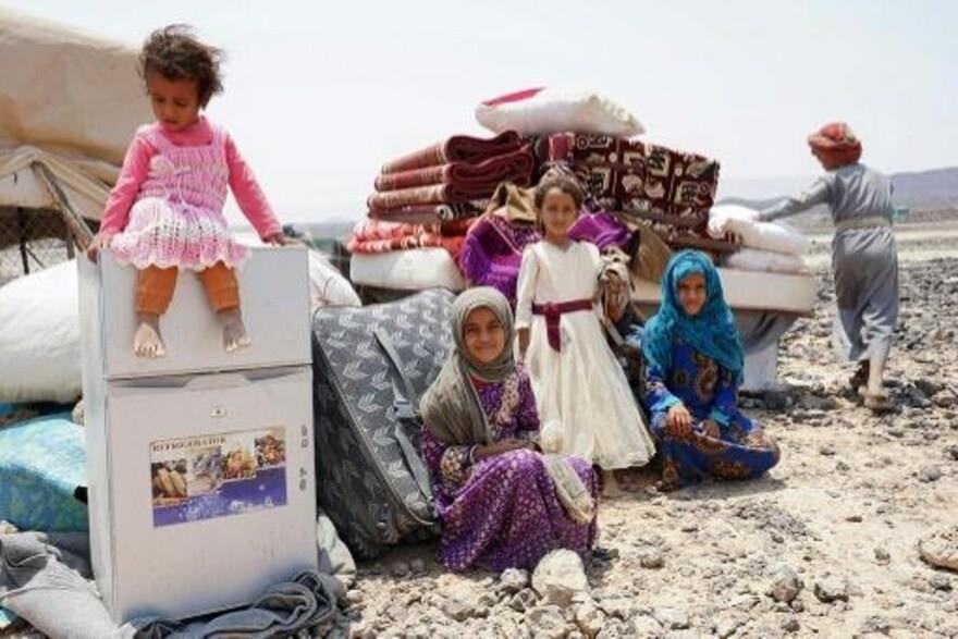 أطفال هادي أحمد هادي يجلسون مع أمتعتهم في مخيم الس