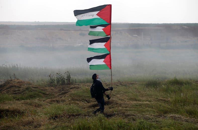 فلسطيني يحمل العلم في يوم الأرض