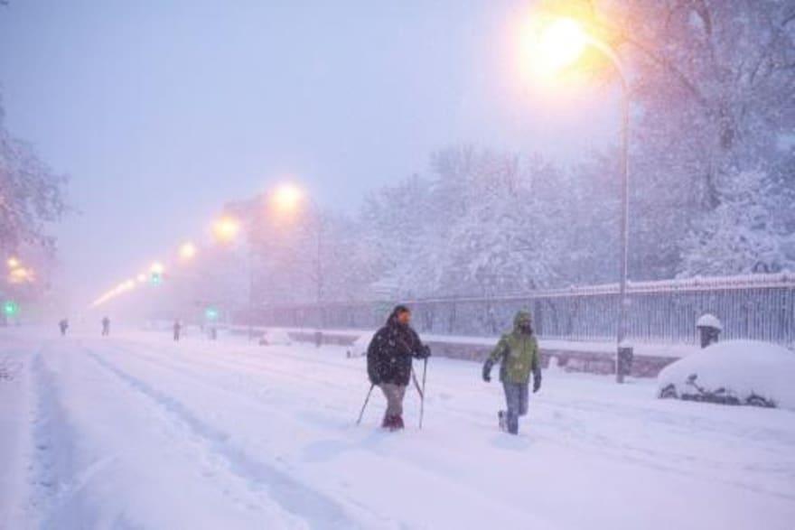 شخصان في مدريد يمشيان وسط الثلوج