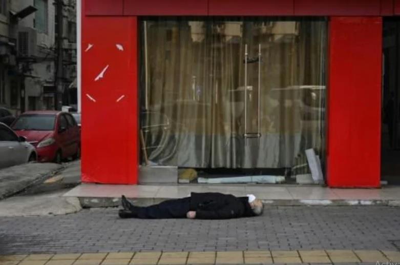 رجل ميت مستلق على رصيف في مدينة ووهان الصينية