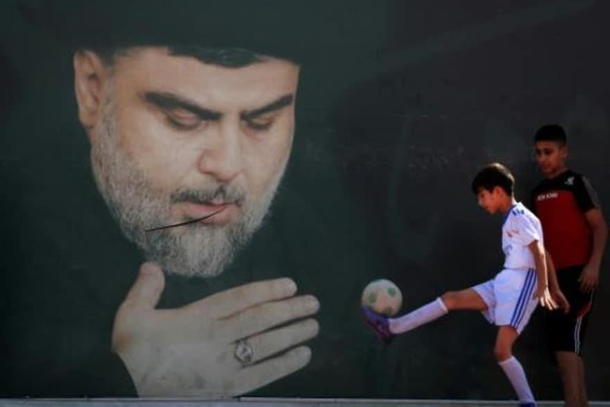 أطفال عراقيون يلعبون قرب صورة كبرى للزعيم الشيعي ا