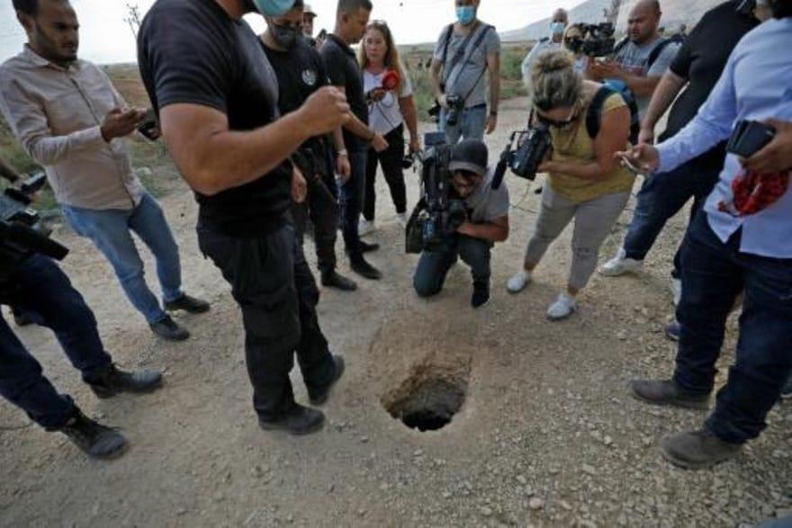 عناصر شرطة إسرائيلية وصحافيون يتجمعون حول حفرة است