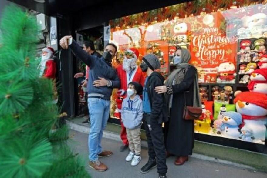 أفراد عائلة إيرانية يلتقطون صورة سيلفي مع رجل يرتد