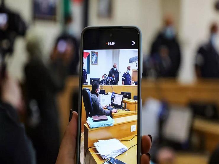 سيدة تستخدم هاتفها الذكي للتصوير في قاعة محكمة ناب