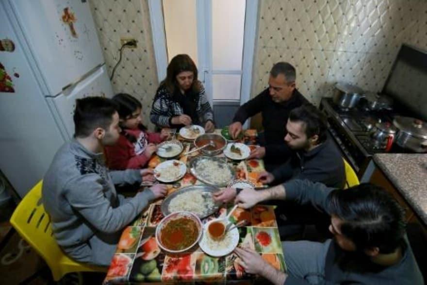 اللاجئ العراقي المسيحي سعد هرمز يجلس مع زوجته وابن