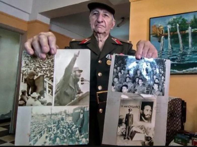ريغوبيرتو سيلوريو يحمل صورا لفيدل كاسترو في منزله