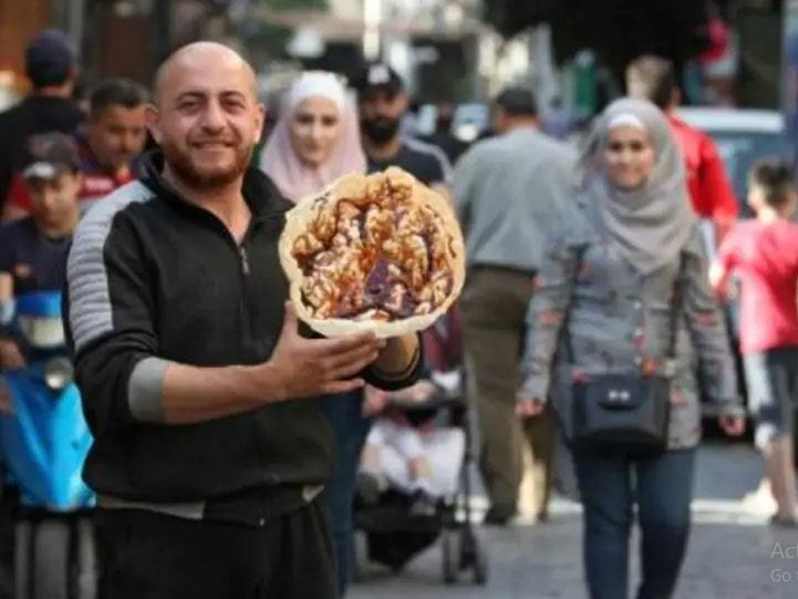 بائع سوري يعرض حلوى الناعم في دمشق