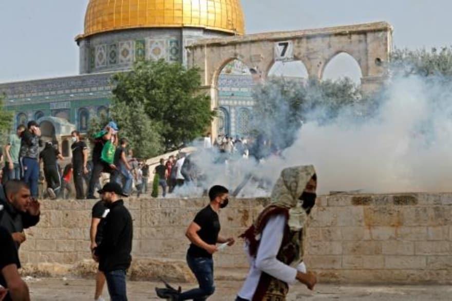 متظاهرون فلسطينيون يهربون من قنابل الغاز المسيل لل