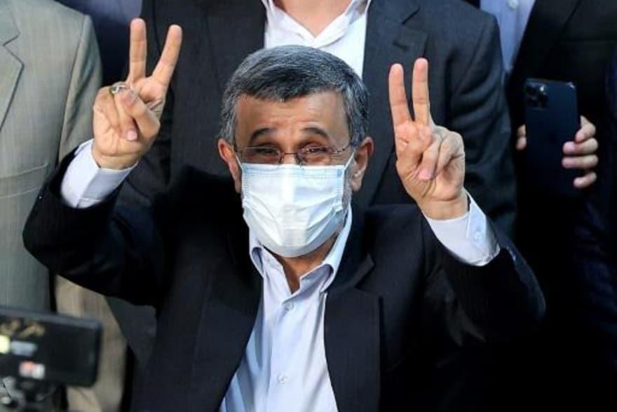 الرئيس الإيراني السابق محمود أحمدي نجاد يرفع شارة 
