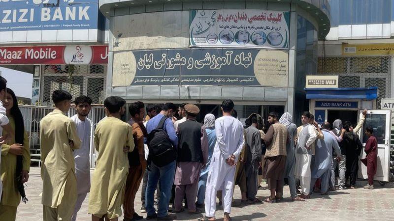 أفغان يصطفون خارج بنك لسحب أموال وسط أزمة مالية في