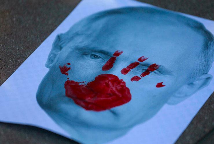 صورة لبوتين وعليها يد حمراء خلال تظاهرة داعمة لأوك