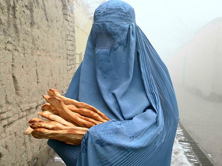 نقبة تحمل خبزا وزعته حملة أنقذوا الأفغان من الجوع 