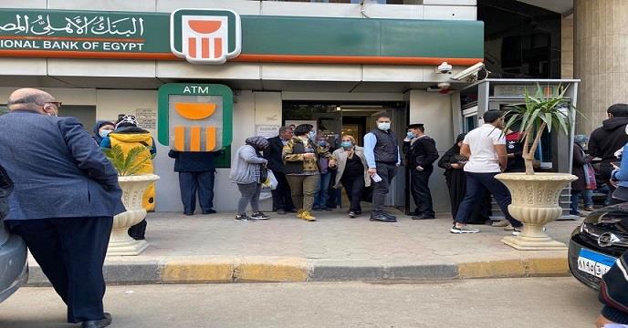 مواطنون أمام أحد فروع البنك الأهلي في انتظار الدخو