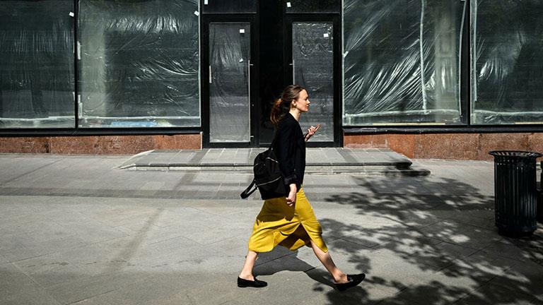 امرأة تمر من أمام متجر مغلق في وسط موسكو