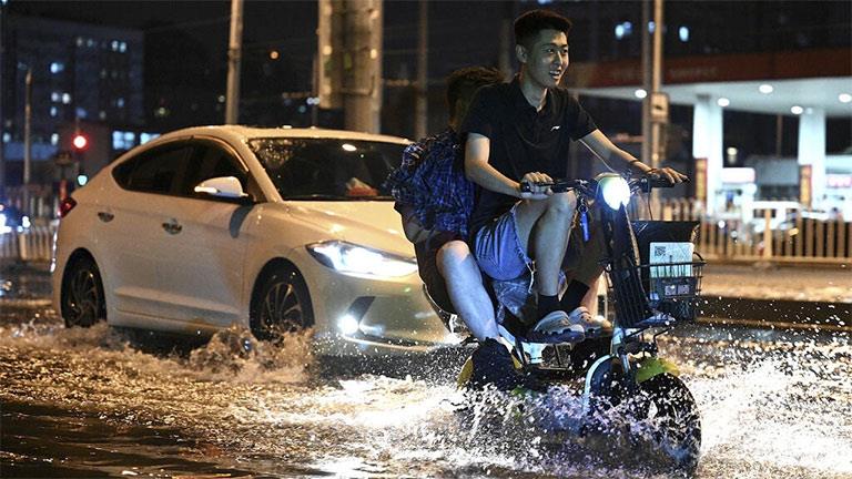 شخص على دراجة نارية بعد هطول أمطار في بكين