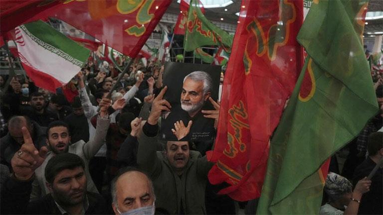 رجال يرفعون أعلام إيرانية وإسلامية بمناسبة ذكرى مق