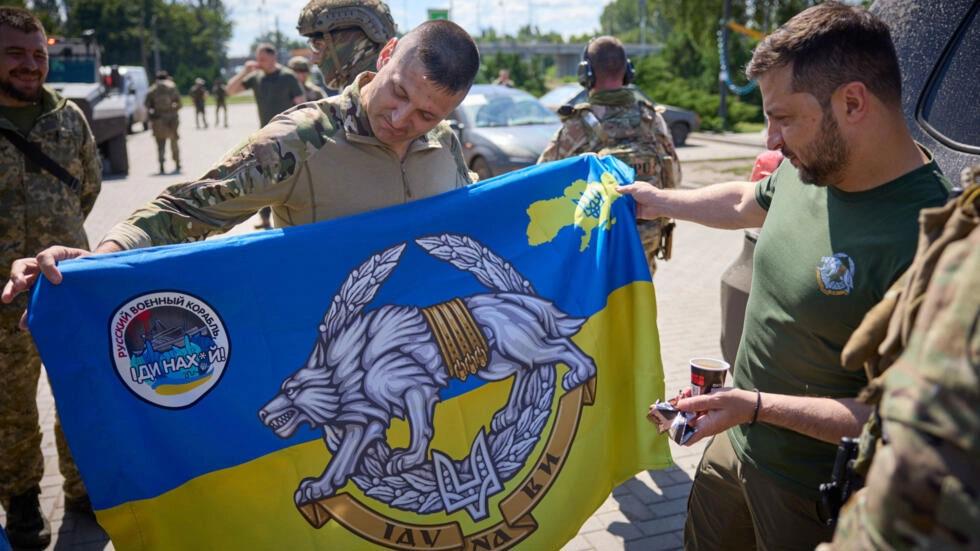 جندي أوكراني يُظهر للرئيس فولوديمير زيلينسكي العلم