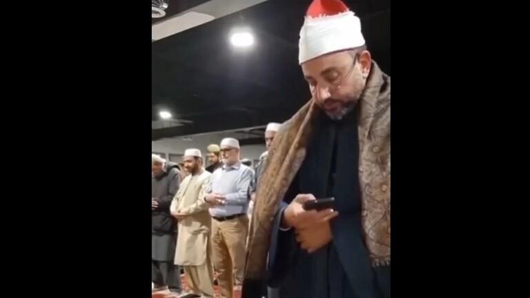 إمام يصلي بالناس ويقرأ من الموبايل 