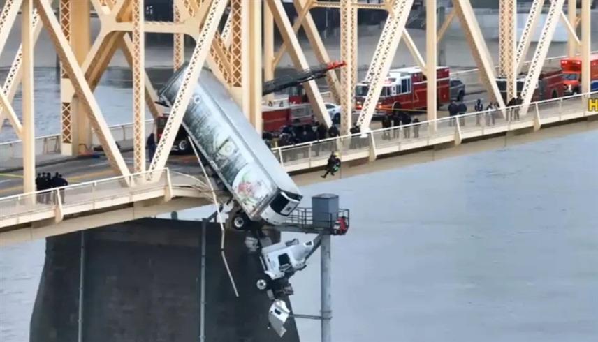 إنقاذ سائق من شاحنة تتدلى من جسر