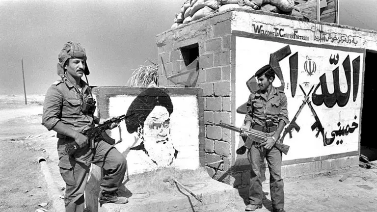 جنود عراقيون يقفون أمام حائط رسم عليه صورة لآية الله الخميني عند نقطة عسكرية داخل الأراضي الإيرانية، وذلك خلال الحرب العراقية الإيرانية