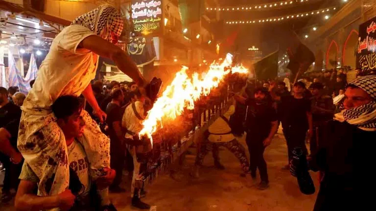 مسلمون شيعة يحملون مشاعل في طقوس قبيل عاشوراء في النجف
