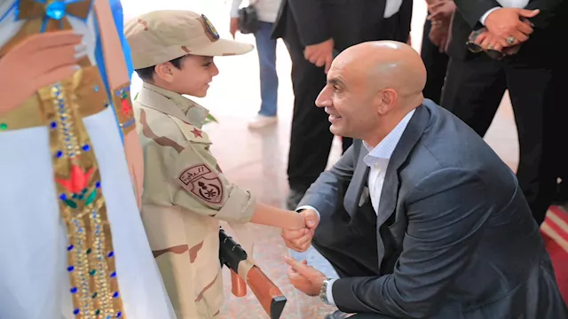 وزير التعليم يصافح طفلاً بزي عسكري