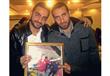 محمود-مع-أبو-تريكة-يحملان-صورة-شقيقه-الشهيد                                                                                                                                                             