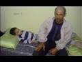 الطفل سعد أثناء رقوده على الفراش ووالده بجواره                                                                                                                                                          