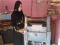 نجوى تقف أمام ماكينة الطباعة تترقب طبع الورق                                                                                                                                                            