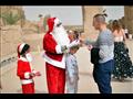 بابا نويل يوزع الهدايا والورود على السائحين في معبد الكرنك 