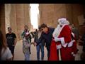 بابا نويل يوزع الهدايا والورود على السائحين في معبد الكرنك 