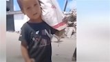 طفل فلسطيني يحمل كيس طحين
