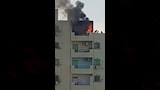 محاولات الجيران اخماد الحريق من سطح العقار 
