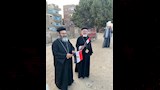 رجال الدين المسيحي ممسكين بعلم مصر خلال توزيع إفطار صائم