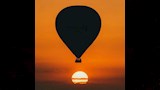 صورة ظلية لمنطاد الهواء الساخن أمام غروب الشمس الناري