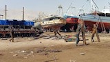 عمال ينقلون الاخشاب المخصصة لسحب المراكب 