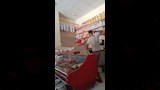 المتهم يعتدي على الشاب داخل المحل