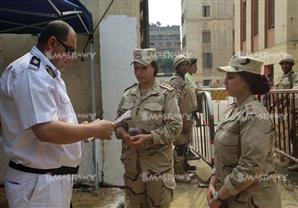 "المعاملة ميري".. ضابط شرطة بالدقي يفحص أوراق "ضابطات" جيش قبل تصويرهن للجان 