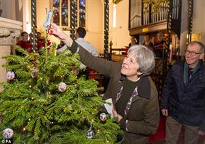 بالصور: رئيسة وزراء بريطانيا تتوج شجرة عيد الميلاد بحذائها الفضي