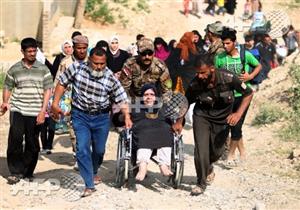 صورة وخبر: رحلة نزوح في الموصل تقودها سيدة على كرسي متحرك