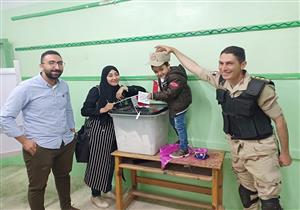 زوجة الشهيد محمود منير تصطحب نجلها حاملًا صورة والده أثناء الاستفتاء بالشرقية - صور